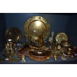 A large collection of brass and copper wares including candle snuffer, chargers, miniatures and