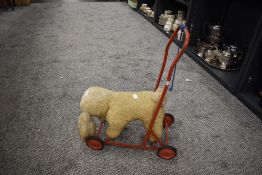 A mid century push along dog toy on wheels.