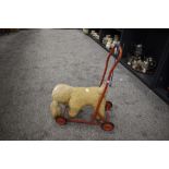 A mid century push along dog toy on wheels.