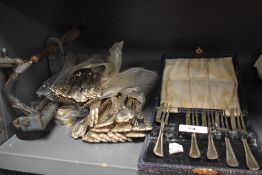 A mixed collection of plated flatware including teaspoons, forks and a vintage apple peeler.