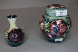 A Moorcroft ginger jar and a bud vase both having green ground with anemone pattern.