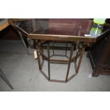 A glass top brass octagon table of geometric form, width approx 96cm