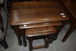 A vintage dark oak nest of three tables