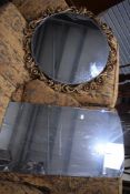 A circular wall mirror with gilt effect frame and similar mirror