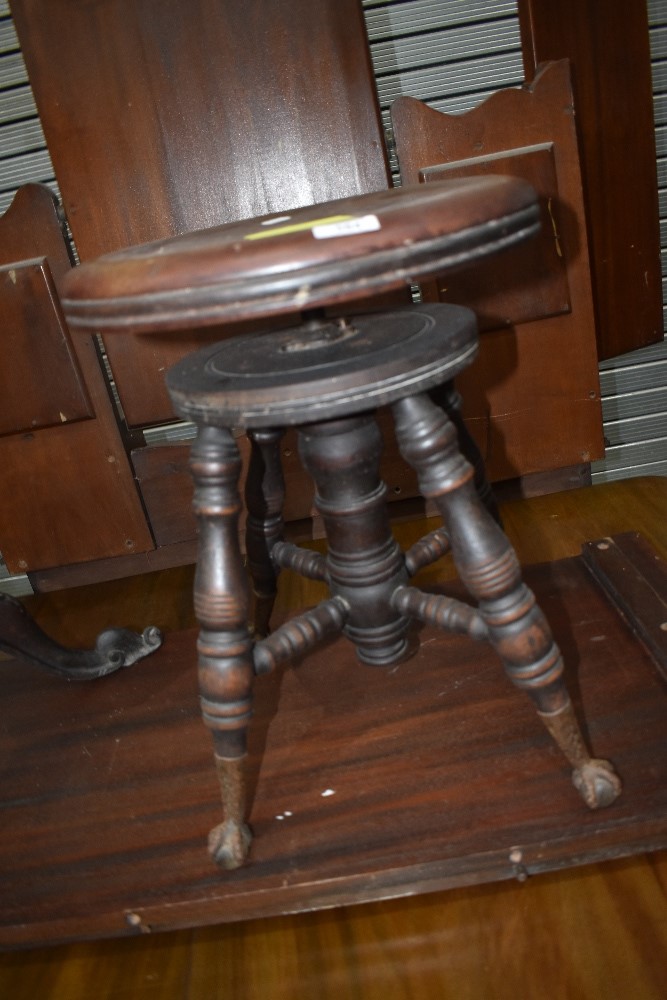 An adjustable piano stool with eagle foot and glass ball feet