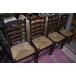A set of four traditional oak ladder back chairs having rush seats