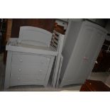 A modern grey painted nursery suite comprising wardrobe, changing drawers and cot