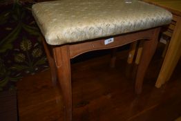 An oak framed piano stool