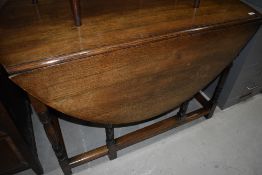 A traditional oak gateleg dining table having turned legs