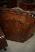 An early Victorian corner cupboard in oak