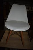 A modern chair in white with vinyl seat