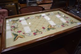 An oak framed embroidered tray