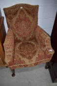 An Edwardian arm chair having period upholstery