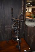 A traditional dark stained spinning wheel