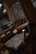 An early 20th Century arts and crafts style folding chair having armorial upholstery
