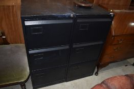 A pair of modern black three drawer filing cabinets