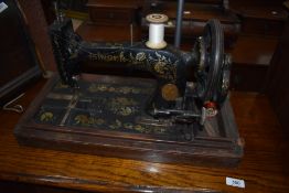 An early hand cranked sewing machine by Singer with case