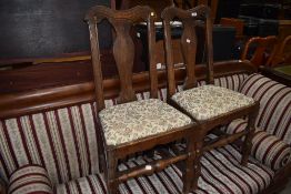A pair of Period oak vase back dining chairs having later upholstery