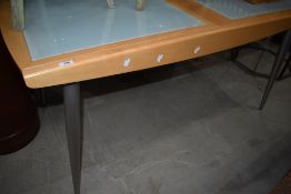 A modern smoked glass and beech effect extending dining table