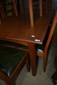 A golden oak dining table with four plus two carver chairs with ladder backs by Peter Hall