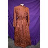 A full length Chinese dressing gown or house coat in terracotta silk or silk blend fabric, frog