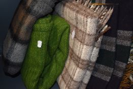 A collection of vintage rugs and blankets including double sided tartan and moss green wool.