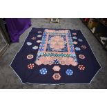 A large vintage patchwork quilt,around 1960s, floral and similar hexagons on navy blue ground.