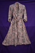 A late 1940s/early 50s pale pink Tootal house coat with black,white and grey floral pattern,