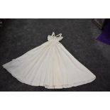 A 1940s cream taffeta gown having unusual straps, fabric concealed side metal zip and beading to