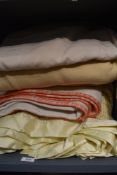 A collection of vintage wool blankets and a monogrammed sheet.