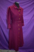 An aubergine wool late 1940s/early 1950s dress having brass button fastening to front and original