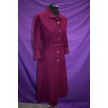 An aubergine wool late 1940s/early 1950s dress having brass button fastening to front and original