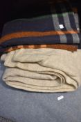 Three vintage blankets including bright checked travel rug.