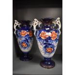 A pair of late 19th early 20th century vases, both tall and having handles, with floral pattern to