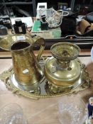 A metal framed hallway mirror a brass oil lamp and a water jug