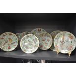 A collection of eight hard paste Chinese plates in Cantonese designs painted with butterfly bird and