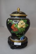 A cloisonne lidded ginger jar decorated with floral scenes on wooden stand