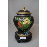 A cloisonne lidded ginger jar decorated with floral scenes on wooden stand