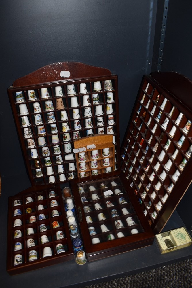 A selection of collectable ceramic and similar thimbles in fitted display cases