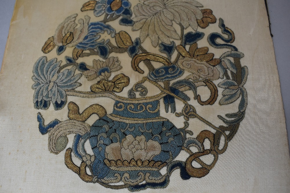 An antique needlework embroidery of a floral vase