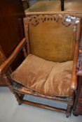 An early 20th century oak monk's chair having table top back and leather studded seat