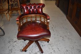 A reproduction leather swivel office chair in the captains style