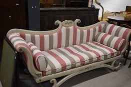 A theatrical classical inspired chaise longue having stripe upholstery and scroll frame