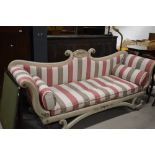 A theatrical classical inspired chaise longue having stripe upholstery and scroll frame