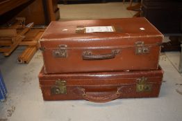 A vintage leather suitcase and a similar period composite suitcase