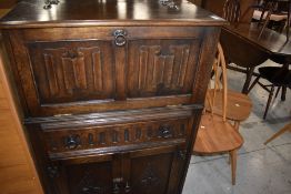 A mid to late 20th Century oak drinks cabinet having linen fold door