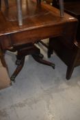 A Regency mahogany table having drop leaves, drawer to one end on quadruple legs with brass feet and