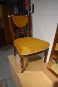 A Victorian stained frame nursing chair having upholstered seat and back panel