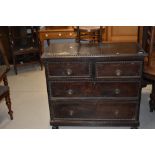 An early 20th century dark stained chest of 2 short and 2 long drawers on turned feet