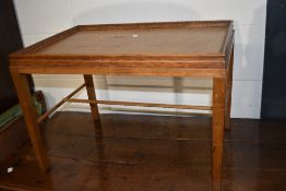 A mid 20th century golden oak bed/occasional table having fixed tray top